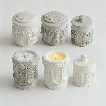 Six original relief candles showing three designs in white and gray finishes, with patterned lids and raised details.