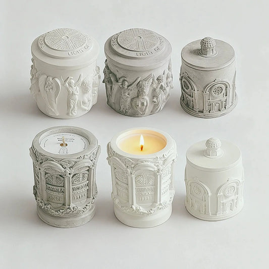 Six original relief candles showing three designs in white and gray finishes, with patterned lids and raised details.