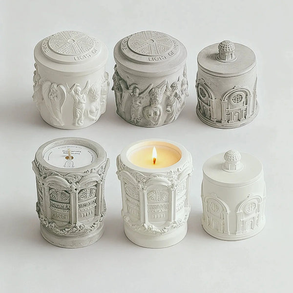 Six original relief candles showing three designs in white and gray finishes, with patterned lids and raised details.