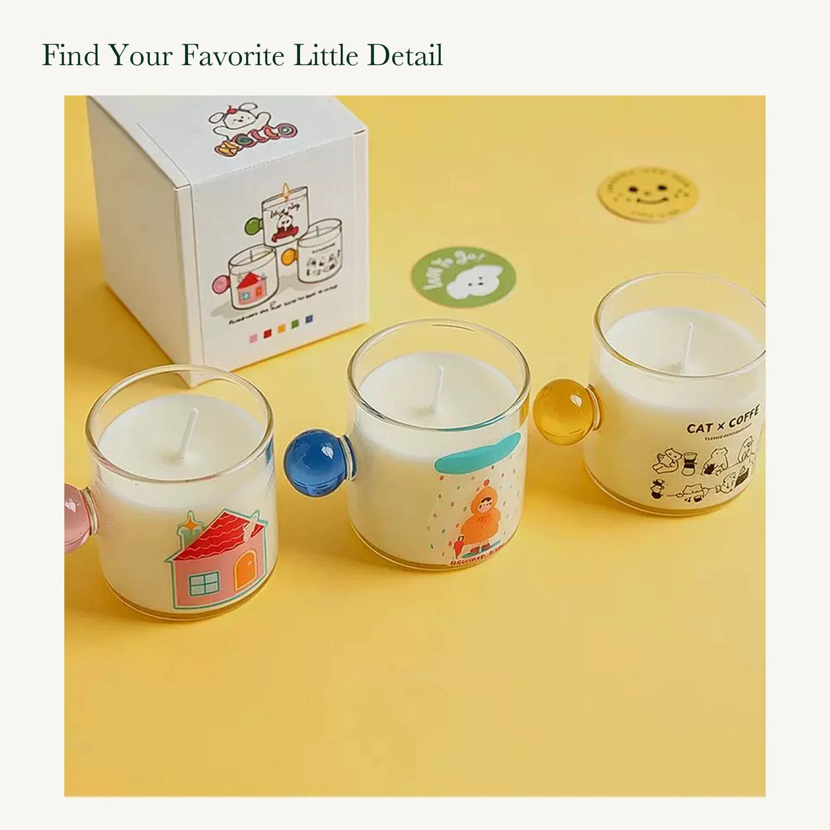 House, rainy-day, and cat illustrated candles with pink, blue, and yellow round handles beside original packaging.