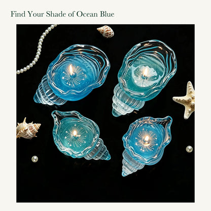 Four conch-shaped glass candles in blue and aqua, showing small and large sizes from above.