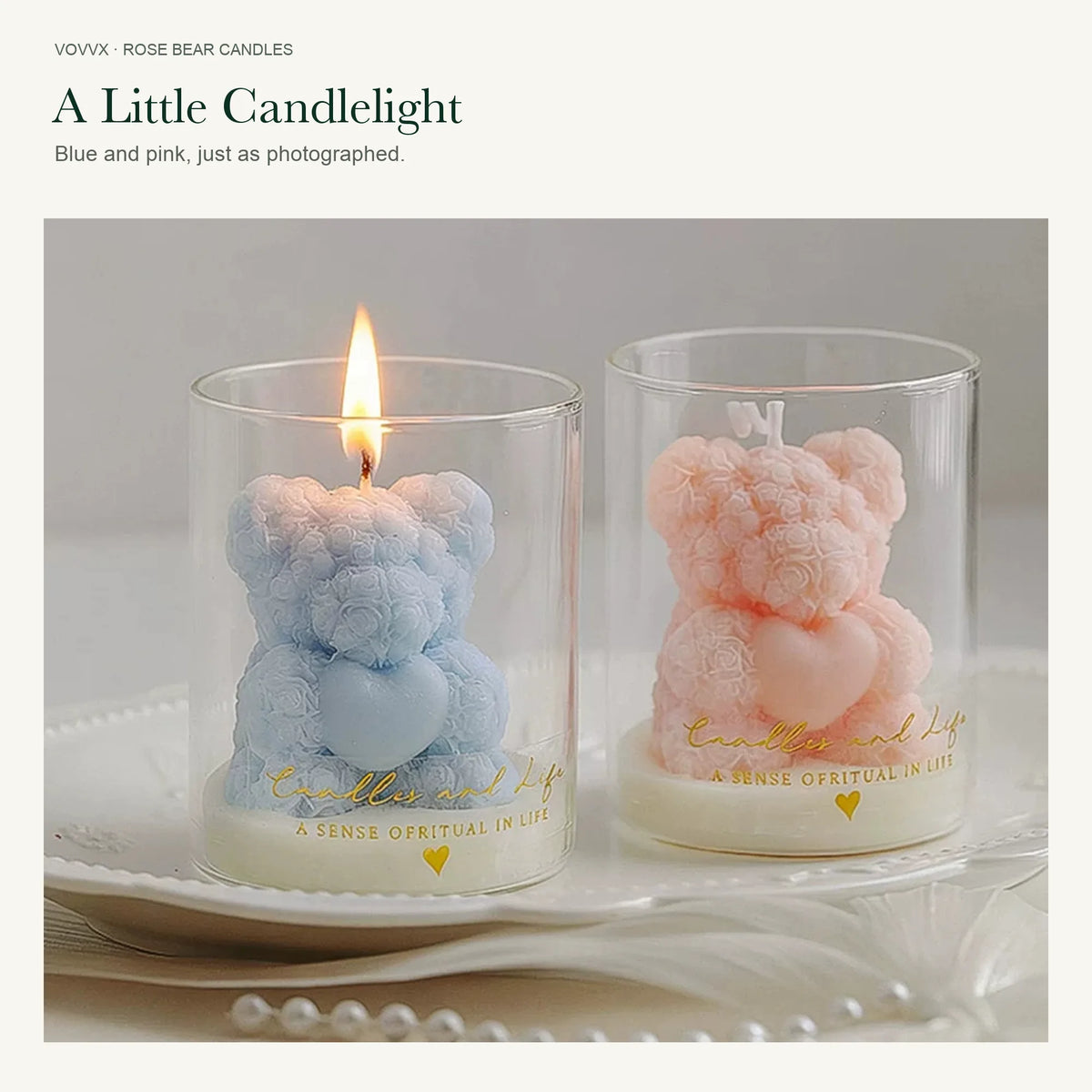 Original blue and pink rose-bear candles in gold-printed glasses, with the blue candle lit.