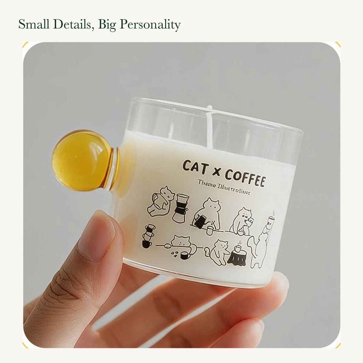 Hand holding the original Cat x Coffee glass candle with a yellow round handle, showing its printed illustration.